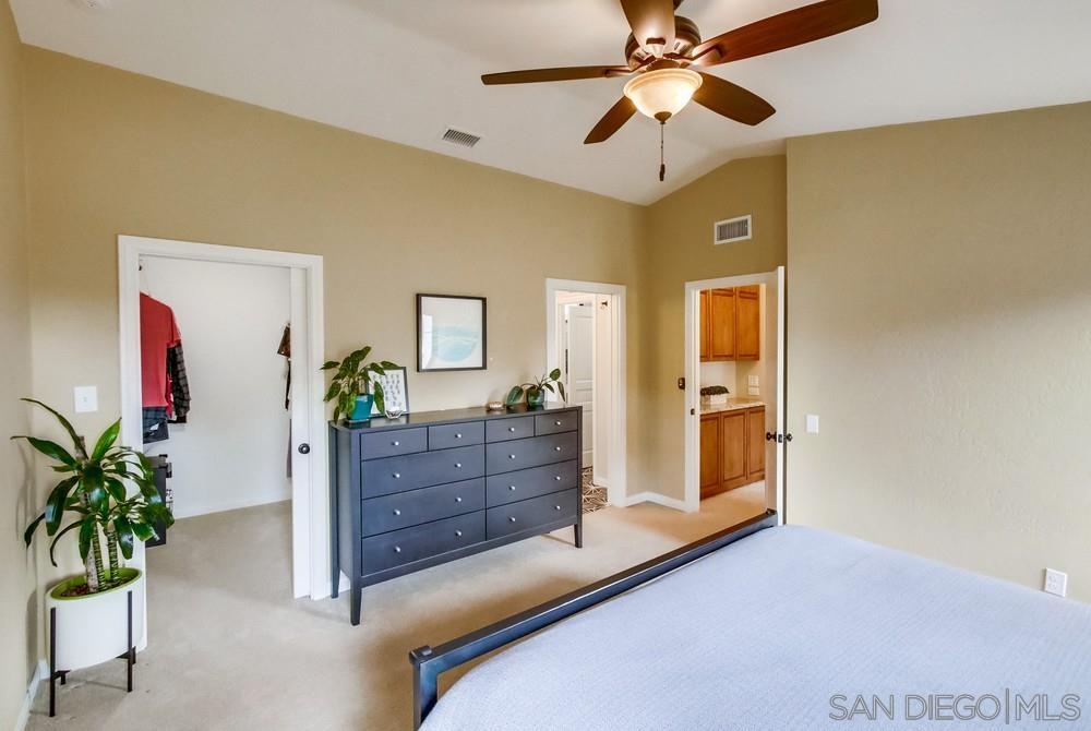 12128 Eagle Street San Diego, CA 92131 - Photo 22 of 37 a room with a bed and a chandelier fan