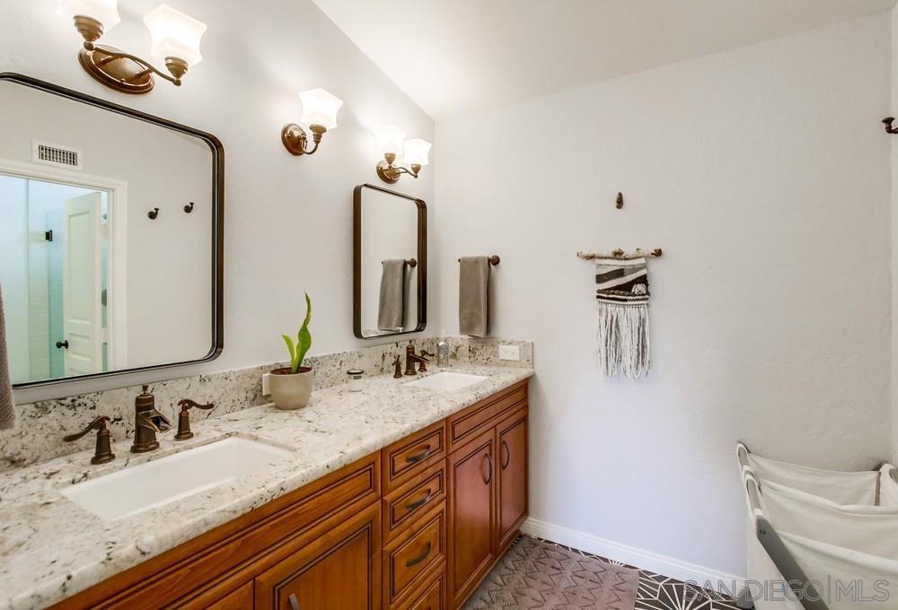 12128 Eagle Street San Diego, CA 92131 - Photo 23 of 37 a bathroom with double vanity sink and a mirror