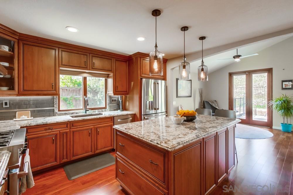 12128 Eagle Street San Diego, CA 92131 - Photo 10 of 37 a kitchen with center island wooden floor center island and stainless steel appliances