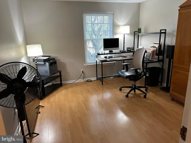 a bedroom with a bed and a lamp on dresser