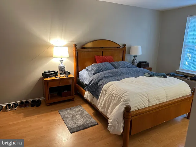 a bedroom with a bed and a lamp on dresser