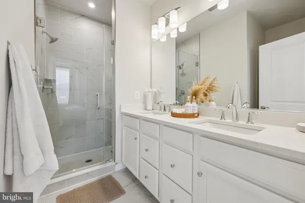 a bathroom with a double vanity sink mirror and shower