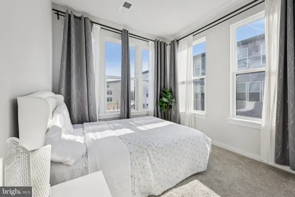 a bedroom with a bed mirror and window