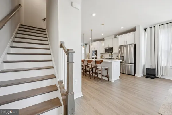 a kitchen with stainless steel appliances refrigerator wooden floor and window