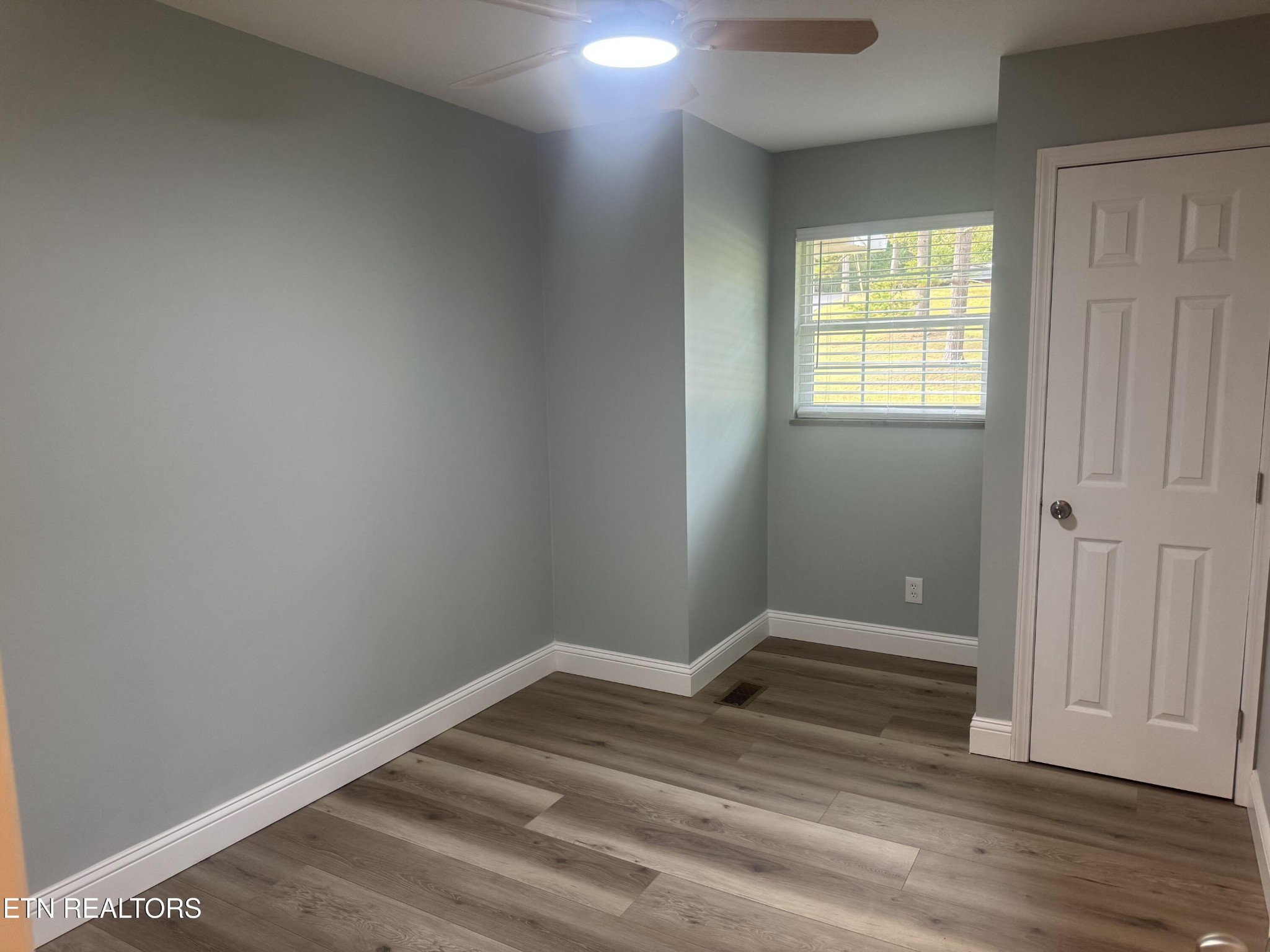 3341 West Wolf Valley Road Clinton, TN 37716 - Photo 28 of 41 an empty room with wooden floor and windows