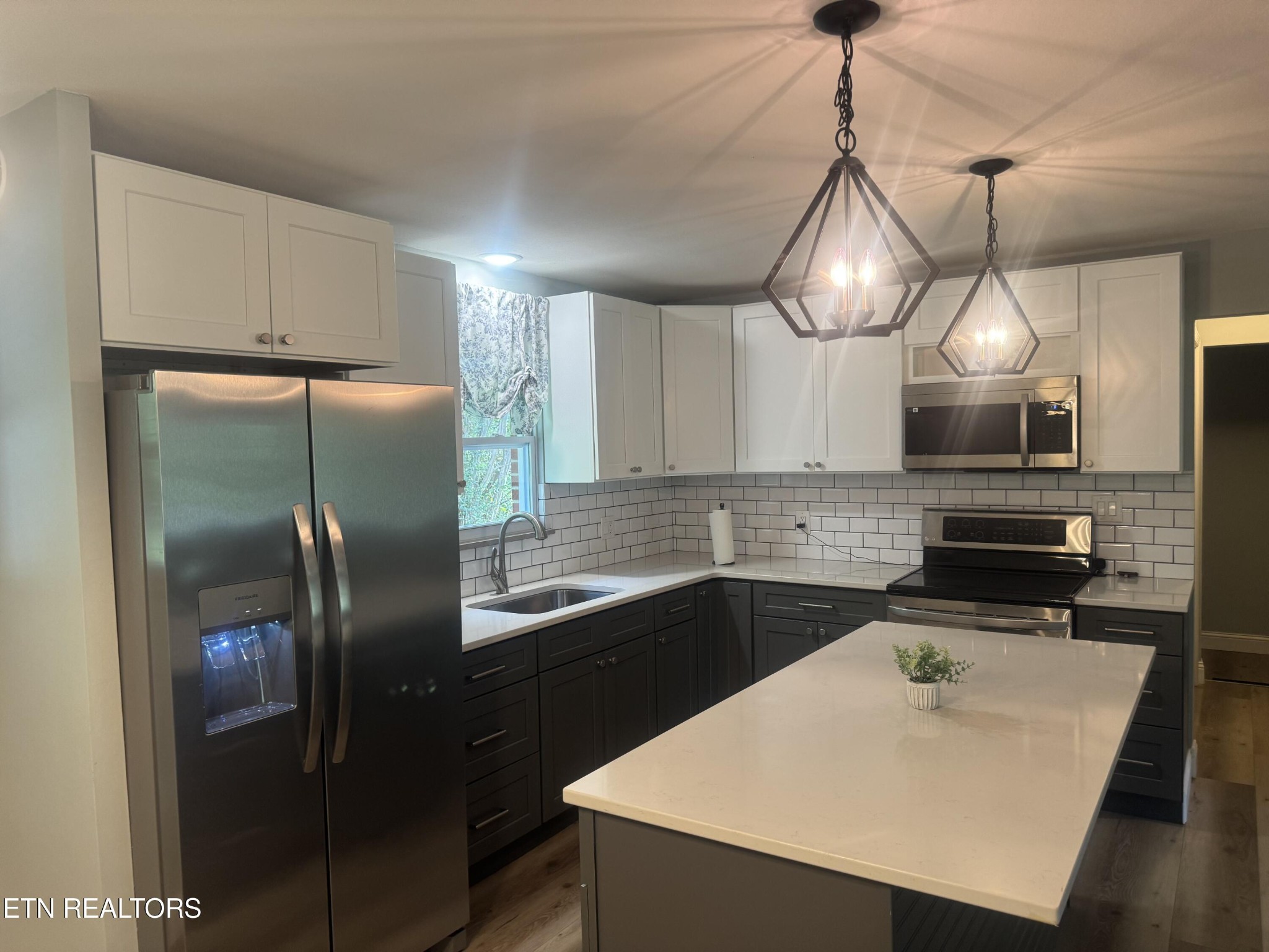 3341 West Wolf Valley Road Clinton, TN 37716 - Photo 10 of 41 a kitchen with stainless steel appliances a sink a refrigerator center island and cabinets