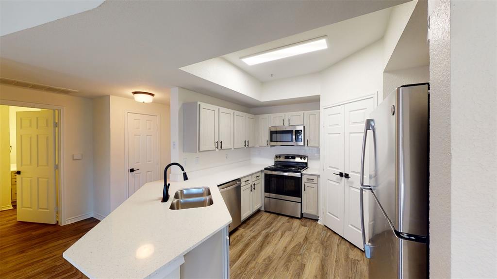 a kitchen with stainless steel appliances a refrigerator sink and stove