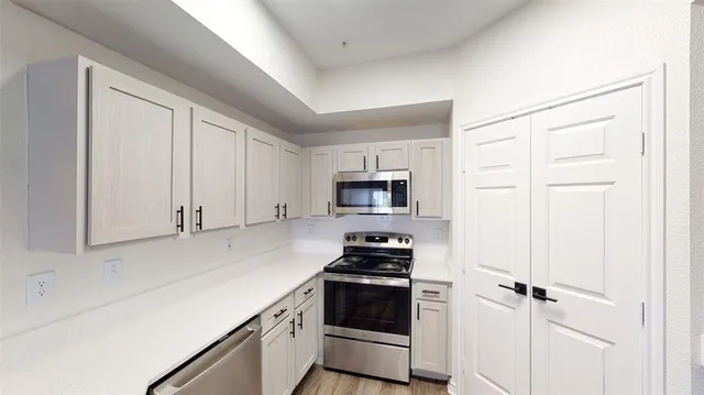 a kitchen with stainless steel appliances white cabinets and a refrigerator