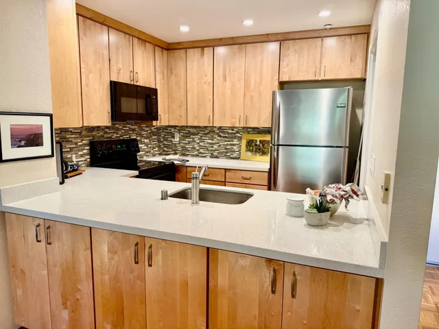 a kitchen with stainless steel appliances a microwave a sink and cabinets