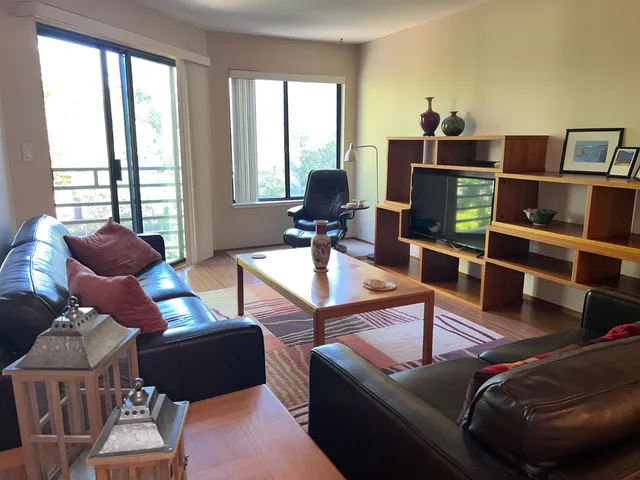 a living room with furniture a flat screen tv and a large window