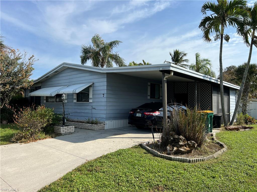 7 Oceans Boulevard, Unit 7 Naples, FL 34104 - Photo 22 of 32 View of home's exterior with a yard and a carport