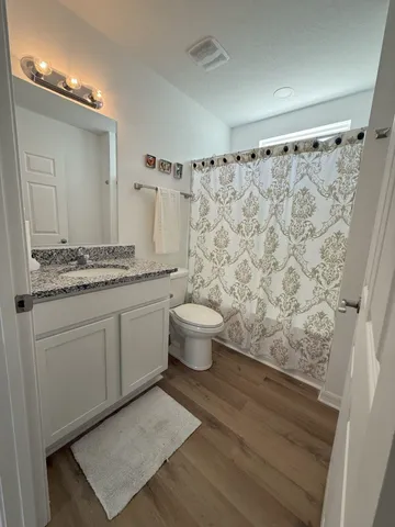 a spacious bathroom with a granite countertop sink mirror and toilet