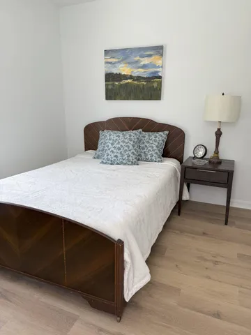 a bedroom with a bed and a lamp on dresser