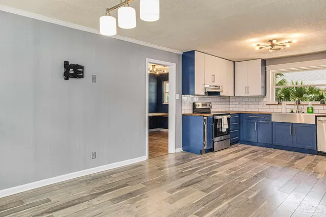 a kitchen with stainless steel appliances granite countertop a stove cabinets and wooden floor