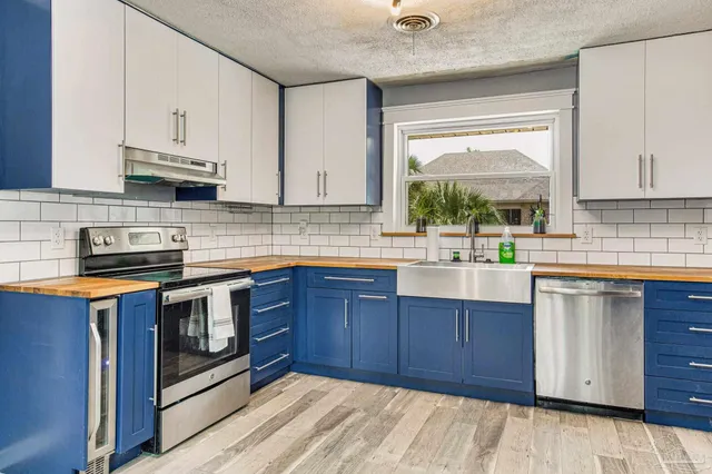 a kitchen with stainless steel appliances granite countertop a sink stove and cabinets