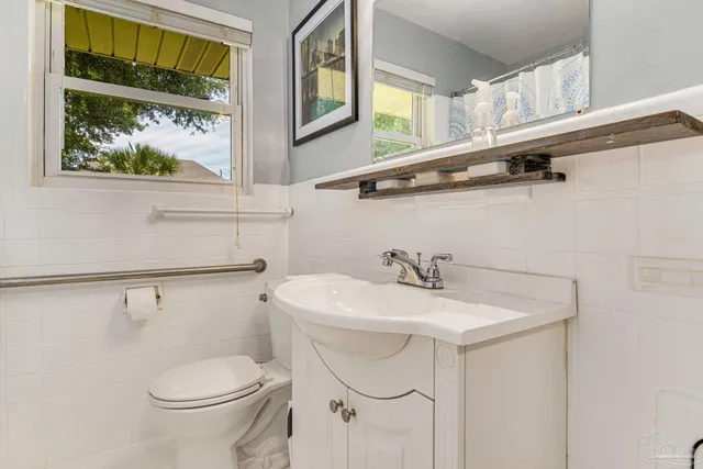 a bathroom with a sink a toilet and a window