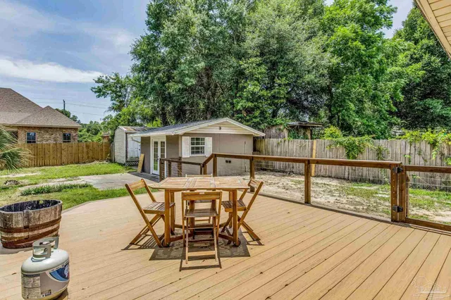 a view of a house with wooden deck and furniture