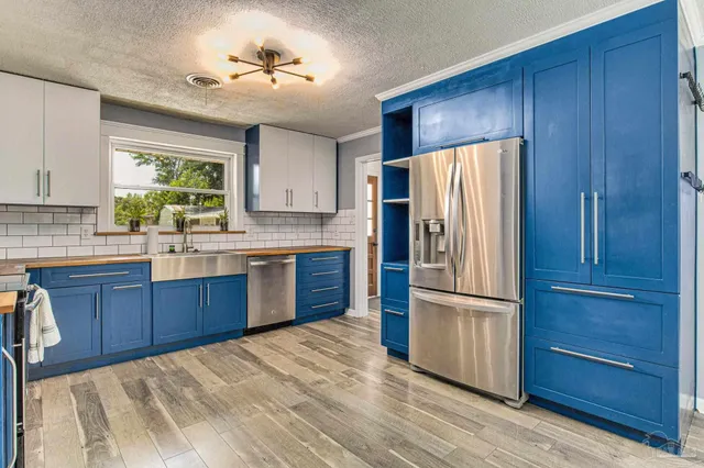 a kitchen with stainless steel appliances granite countertop a refrigerator and a sink