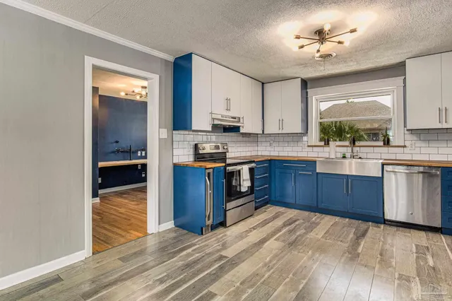 a kitchen with stainless steel appliances granite countertop a stove cabinets and wooden floor