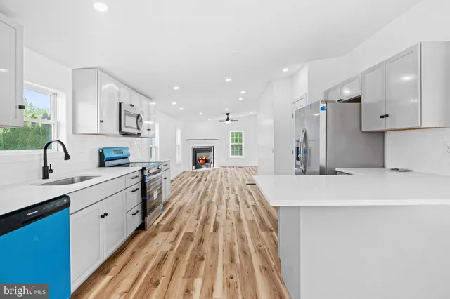 a kitchen with stainless steel appliances granite countertop a refrigerator stove and sink