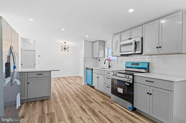 a view of a livingroom with wooden floor and a fireplace