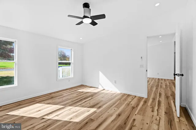 an empty room with window and wooden floor