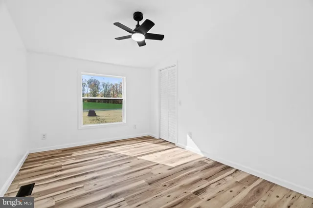 an empty room with a window and closet