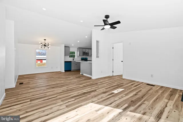 a view of empty room with a kitchen