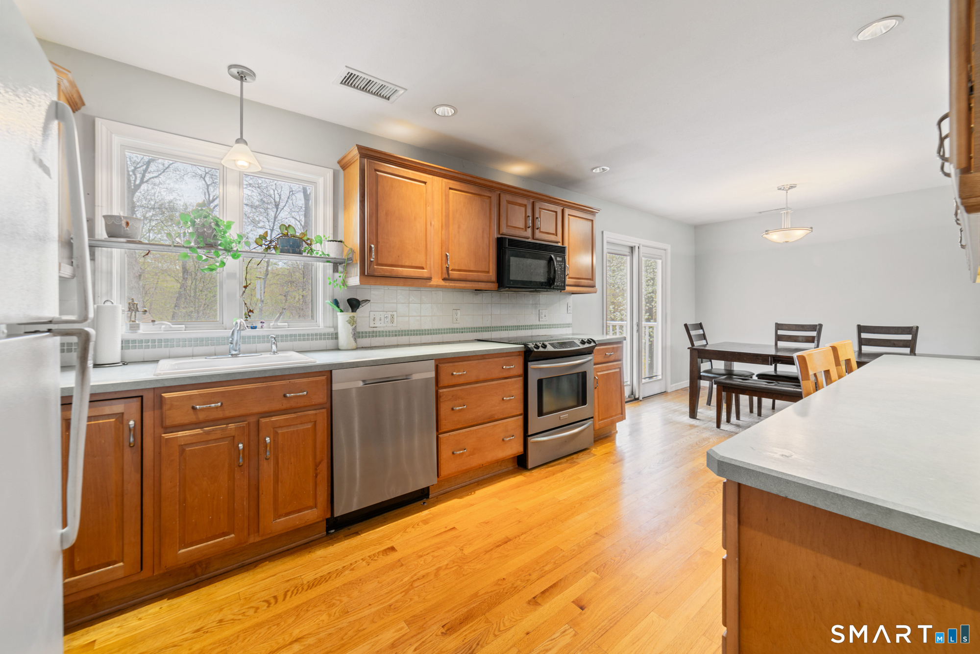 51 Sky View Circle Hamden, CT 06514 - Photo 4 of 40 a kitchen with stainless steel appliances kitchen island granite countertop a stove top oven a sink a dining table and chairs