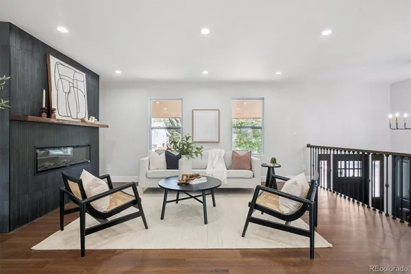 a living room with furniture a fireplace and a wooden floor