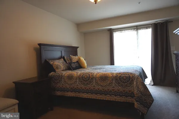 a large bed sitting in a bedroom next to a window