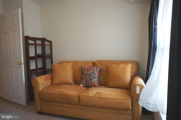 a living room with furniture and a painting on the wall