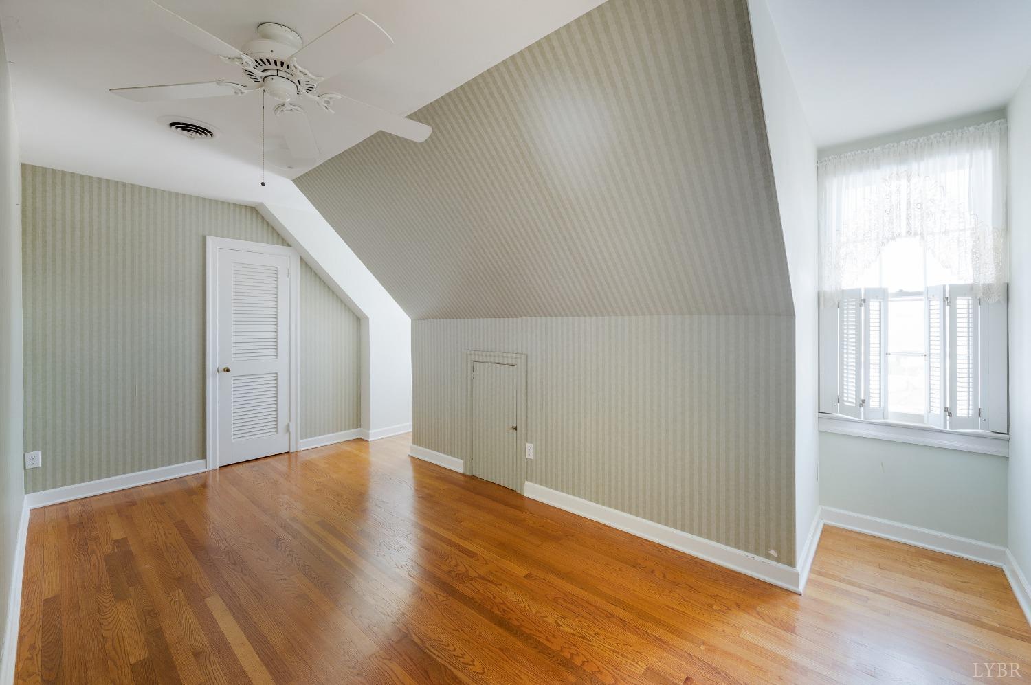 211 Sunset Drive Amherst, VA 24521 - Photo 42 of 76 an empty room with wooden floor ceiling fan and windows