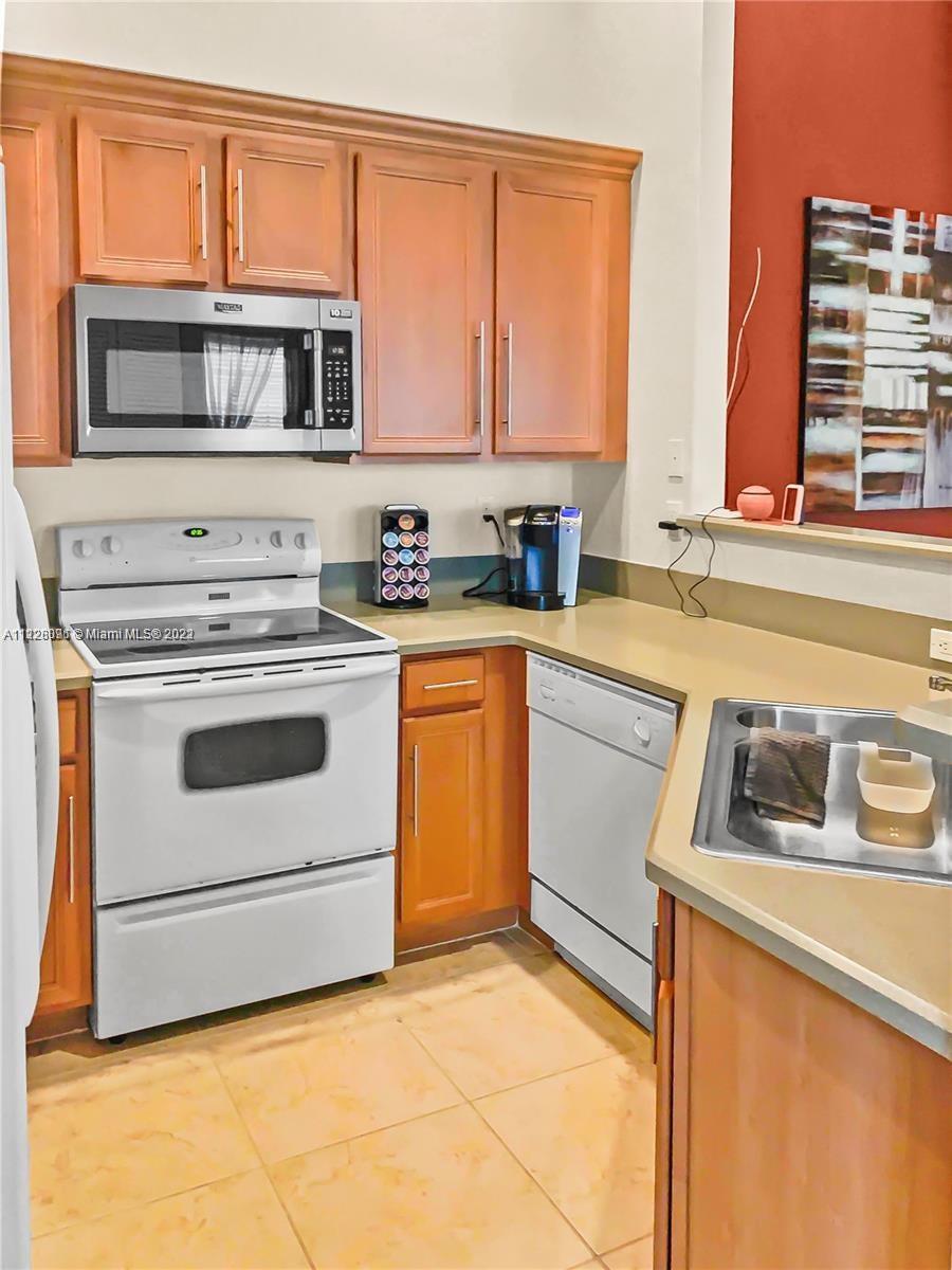 3150 Laurel Ridge Circle, Unit 3150 Riviera Beach, FL 33404 - Photo 12 of 18 a kitchen with a stove microwave and sink