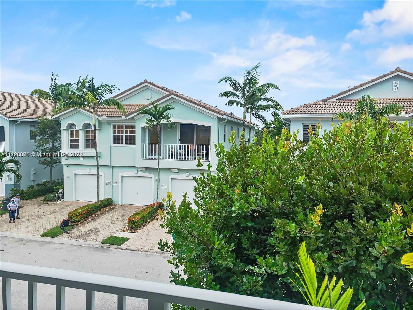 3150 Laurel Ridge Circle, Unit 3150 Riviera Beach, FL 33404 - Photo 3 of 18 a front view of a house with a yard and potted plants