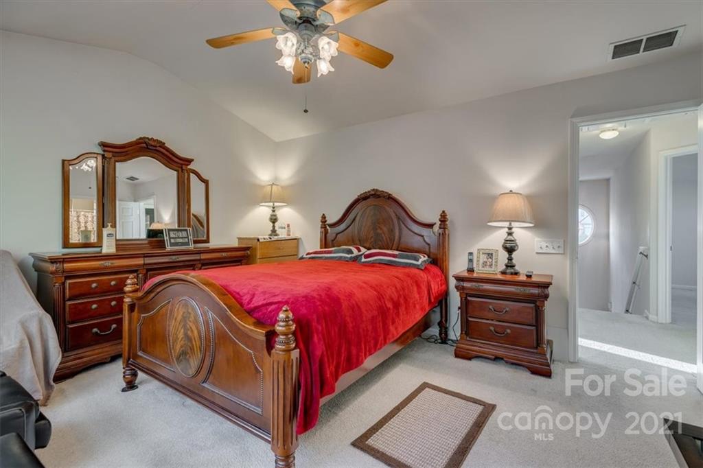 14014 Dingess Road Charlotte, NC 28273 - Photo 23 of 38 a bedroom with a bed and a chandelier