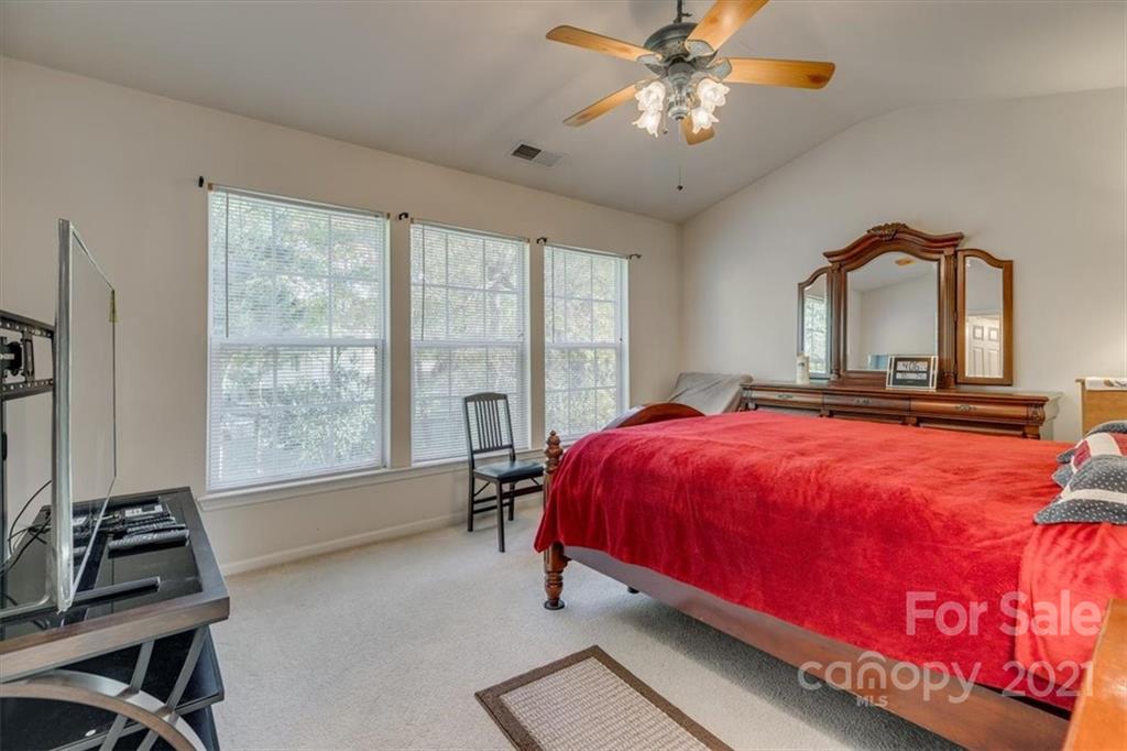 14014 Dingess Road Charlotte, NC 28273 - Photo 24 of 38 a bedroom with a bed and a flat tv screen on the dresser