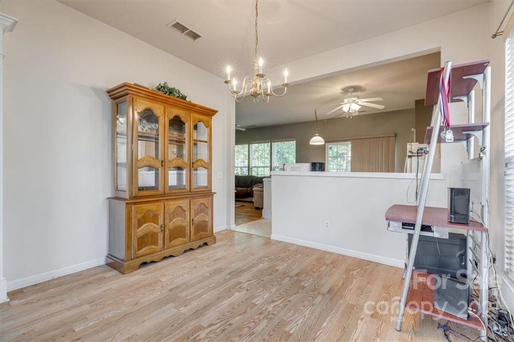 14014 Dingess Road Charlotte, NC 28273 - Photo 8 of 38 a view of a hallway with wooden floor and chandelier