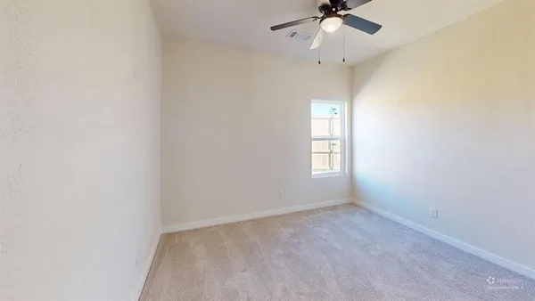 an empty room with a window and a ceiling fan