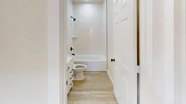 a bathroom with a granite countertop toilet a sink and shower