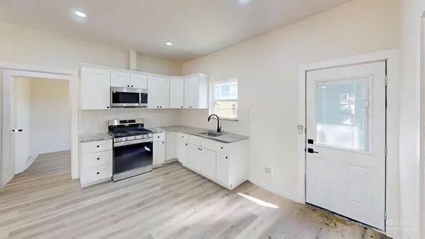 a kitchen with cabinets a microwave oven a sink and dishwasher