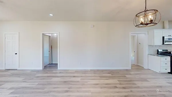 a view of a room with wooden floor and cabinets