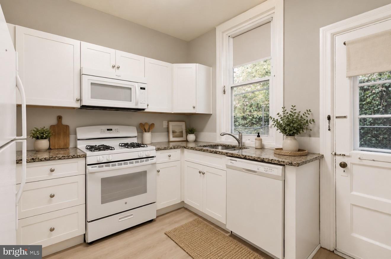 4817 Ridge Avenue Philadelphia, PA 19129 - Photo 6 of 34 a kitchen with granite countertop white cabinets and white appliances