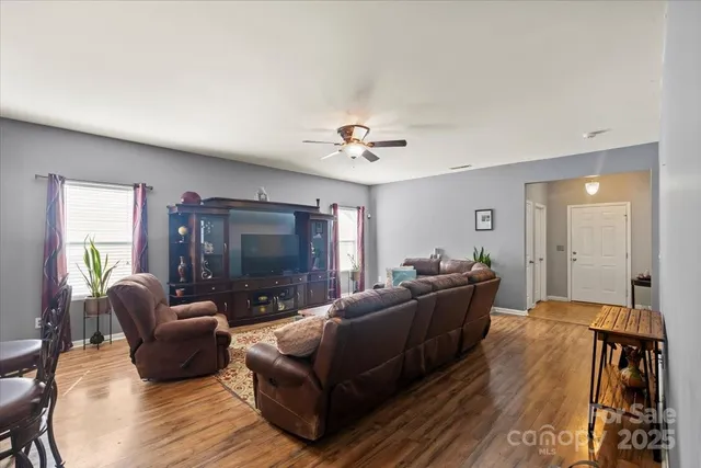 a living room with furniture and a ceiling fan