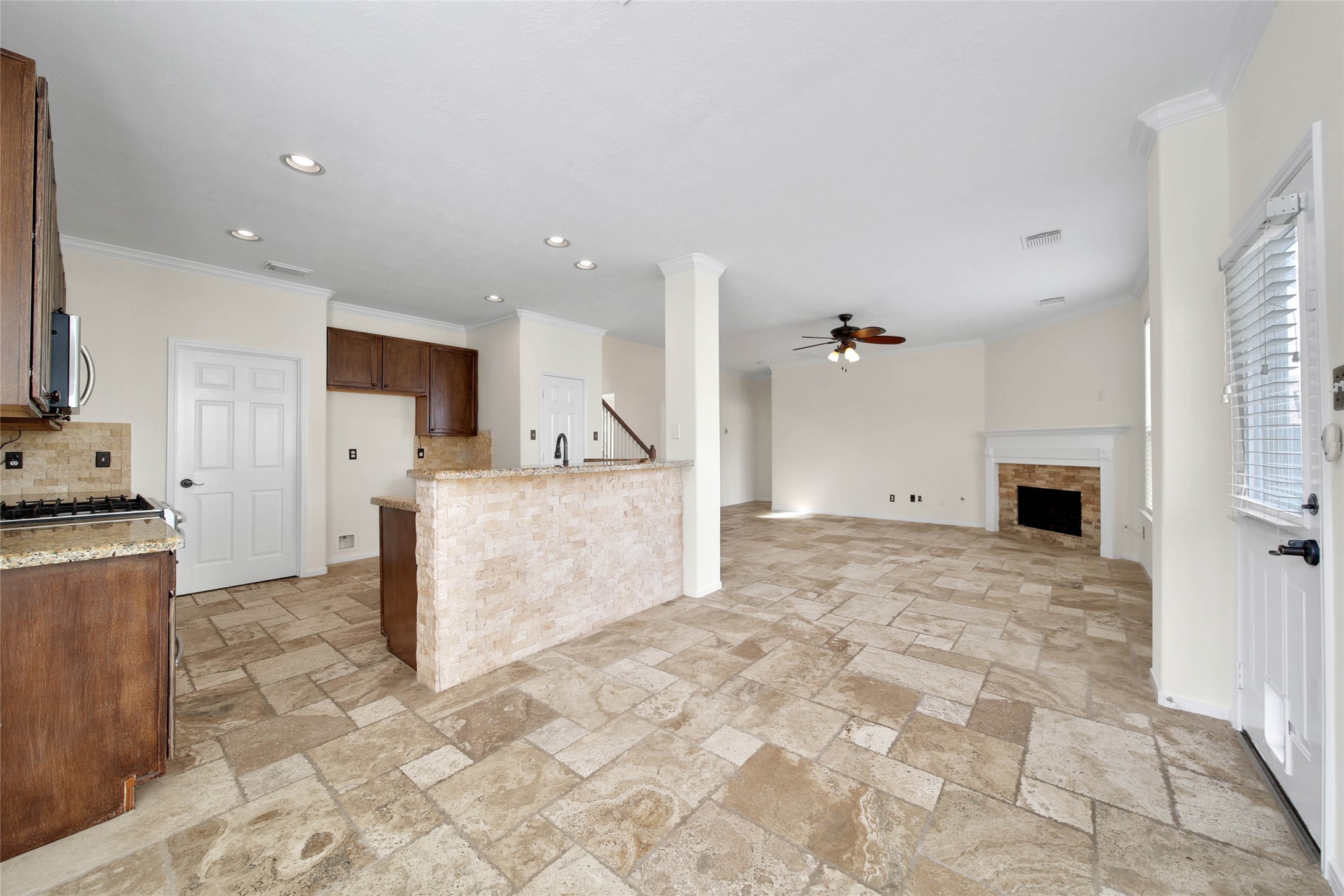 2215 2 Trail Drive Spring, TX 77373 - Photo 14 of 46 The kitchen is open to the family room and breakfast room and features a breakfast bar with a travertine stone accent wall that matches the backsplash.