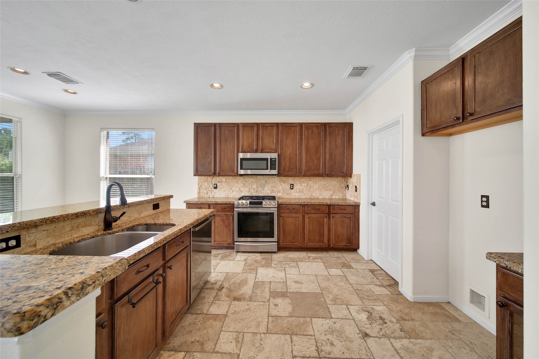 2215 2 Trail Drive Spring, TX 77373 - Photo 15 of 46 Granite counters, travertine backsplash, and stainless appliances in the kitchen. Tons of cabinet and counter space.