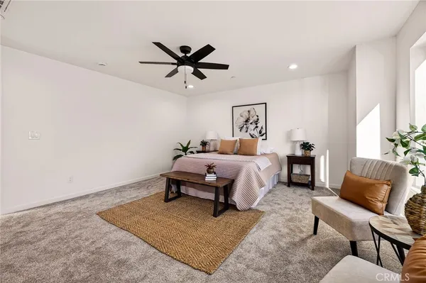 a bedroom with a bed a couch and a potted plant