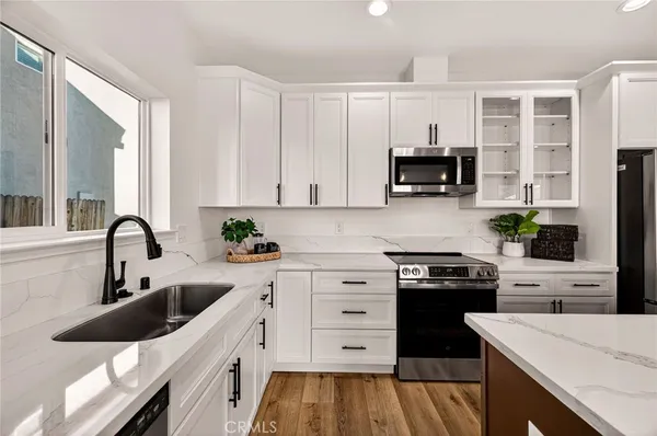 a kitchen with a sink stove top oven and cabinets