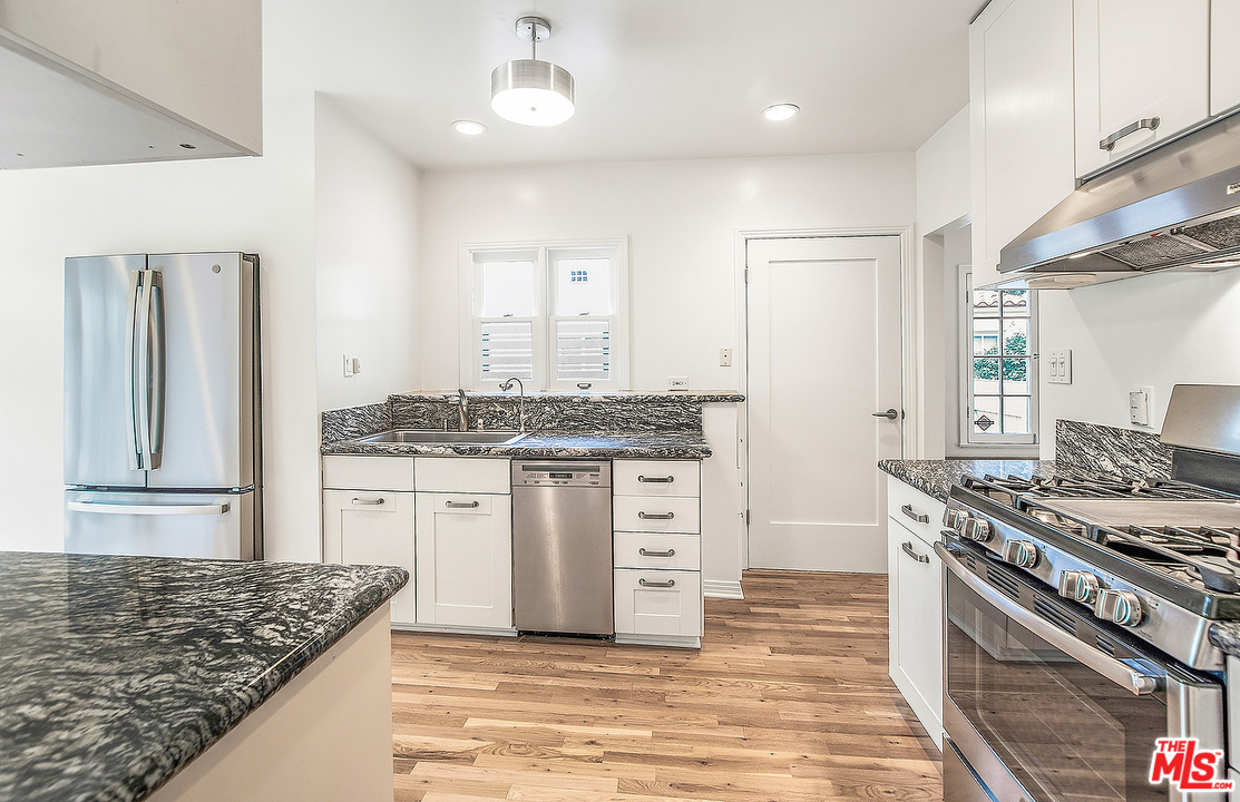 3735 Moore Street Los Angeles, CA 90066 - Photo 11 of 34 a kitchen with granite countertop a sink stove and cabinets