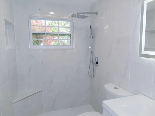 a bathroom with a shower and window